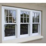 3 PANE UPVC SASH WINDOWS WITH WHITE FRAME ON A CREAM BRICK HOUSE